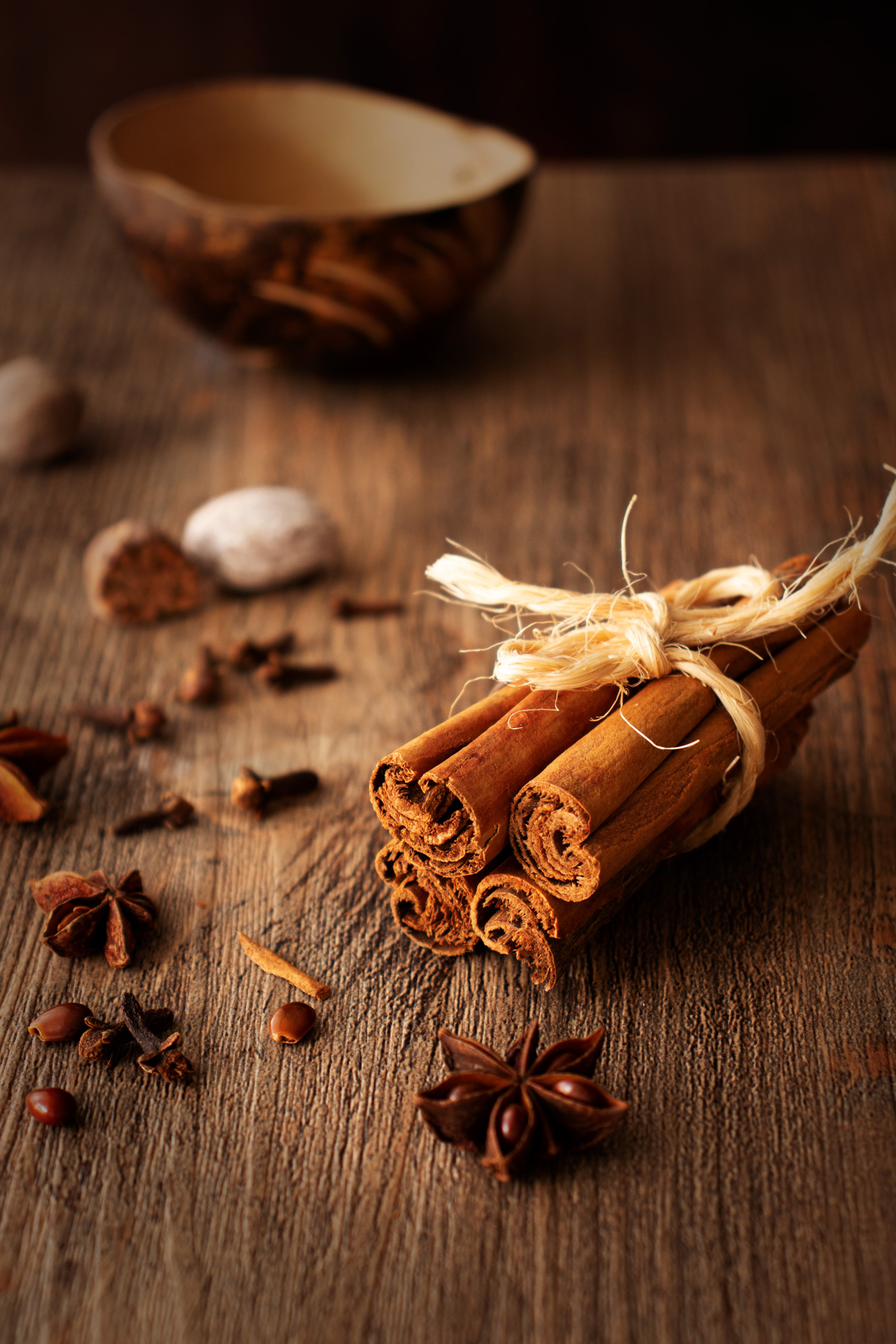 fotografía de atado de canela en astilla con anís y nuez moscada, estilo dark and moody
