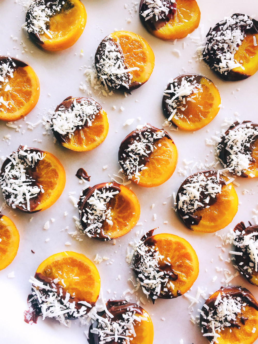 Fotografía de rodajas de naranjas miniaturas confitadas, recubiertas con chocolate y coco