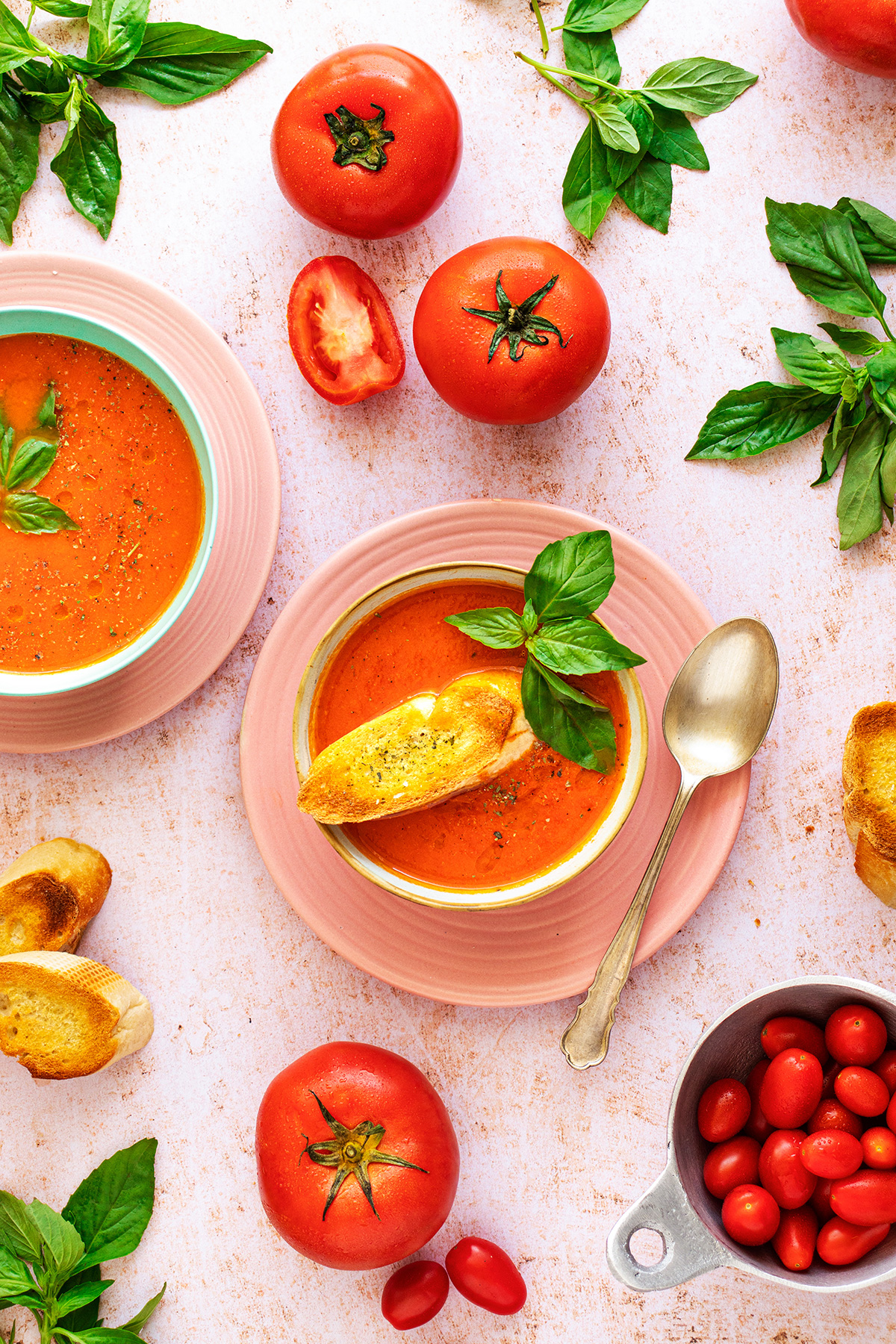 Fotografía de sopa de tomate con pan tostado y albahaca