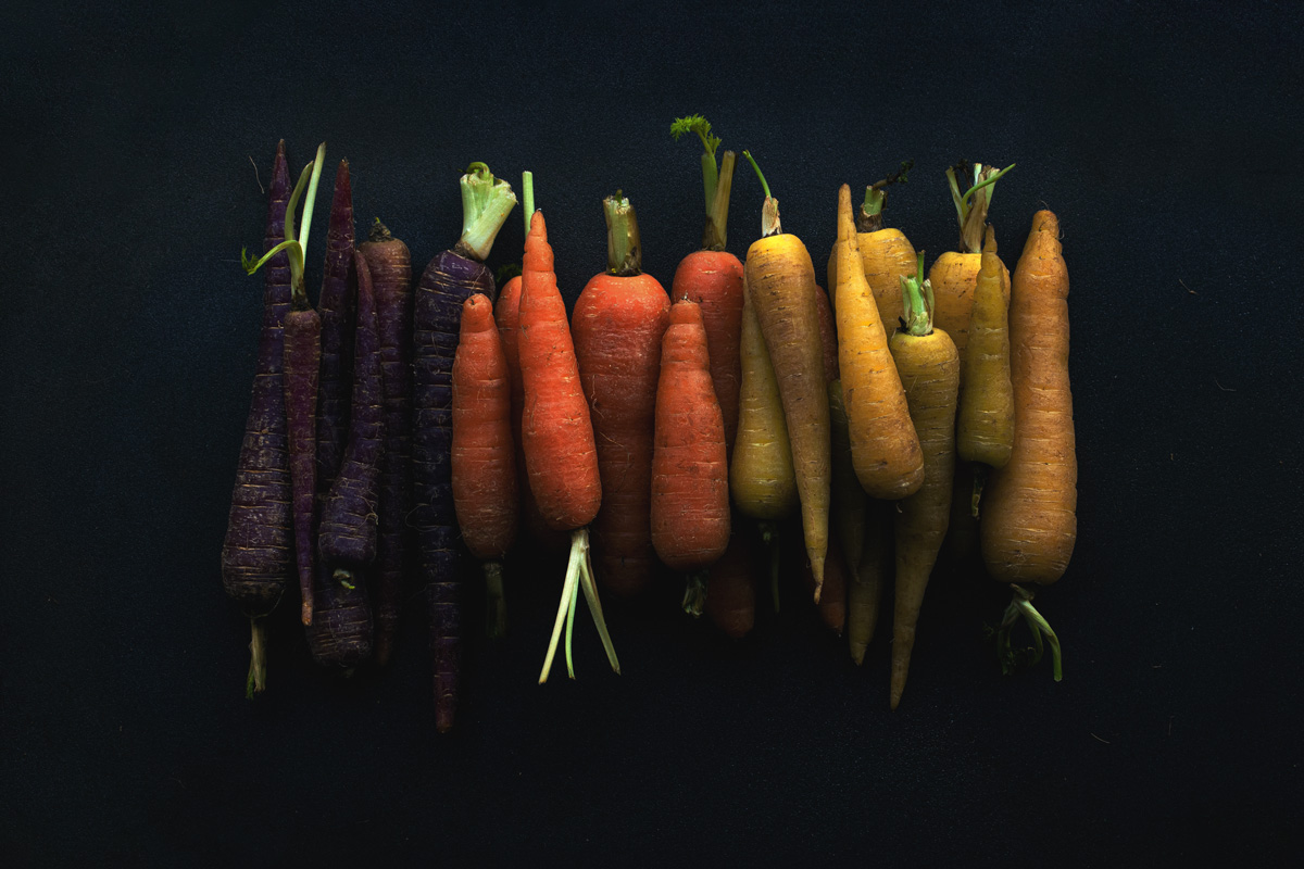 Fotografía de zanahorias multicolor en fondo negro